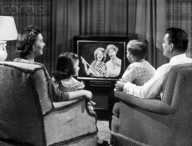 1950s Family Sitting In Easy Chairs Watching Television