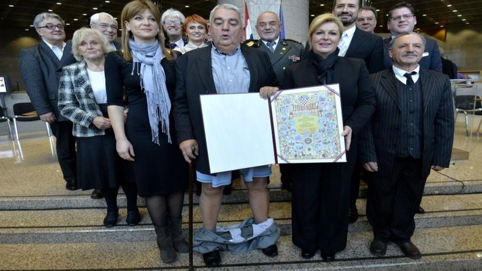 08.12.2015., Zagreb - U NSK povodom Medjunarodnog dana ljudskih prava odrzala se svecana dodjela nagrada Hrvatskog helsinskog odbora za ljudska prava. Clanovi HHO-a od predsjednice Kolinde Grabar Kitarovic dobili Povelju RH, te prilikom zajednickog fotografiranja s predjesdnicom RH, Ivanu Zvonimiru Cicku predsjedniku HHO-a popustile su hlace te pale na pod. Photo: Marko Lukunic/PIXSELL